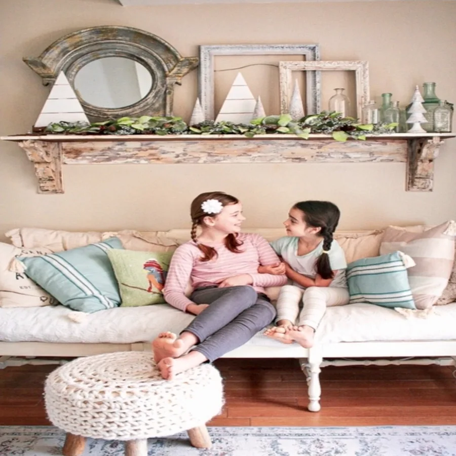 Two daughters on sofa with holiday mantle shelf