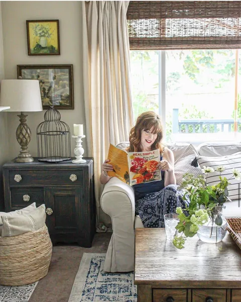 Kirsten reading Real Simple magazine in her living room
